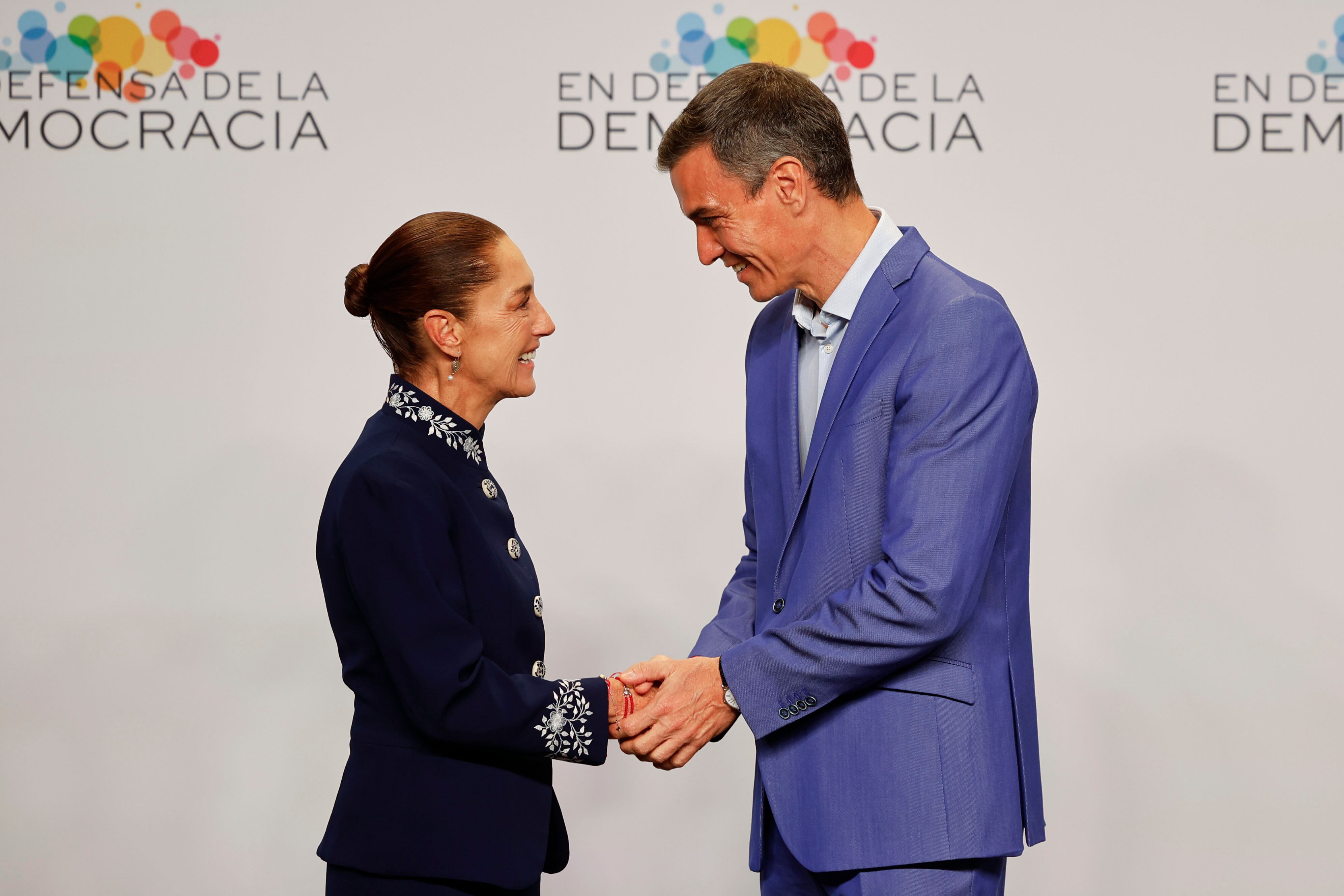 El presidente del Gobierno, Pedro Sánchez (d), saluda a la presidenta de México, Claudia Sheinbaum (i), a su llegada a la IV Cumbre en Defensa de la Democracia celebrada este sábado en Fira de Barcelona para unir fuerzas e intentar parar la ola global de extremismo y populismo.