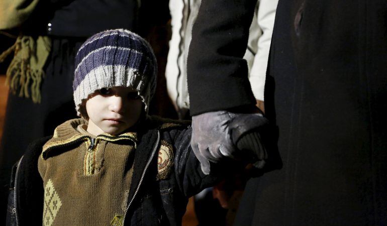 Un niño sirio con su familia, en la ciudad siria de Madaya, bajo asedio de las tropas de Al Asad.