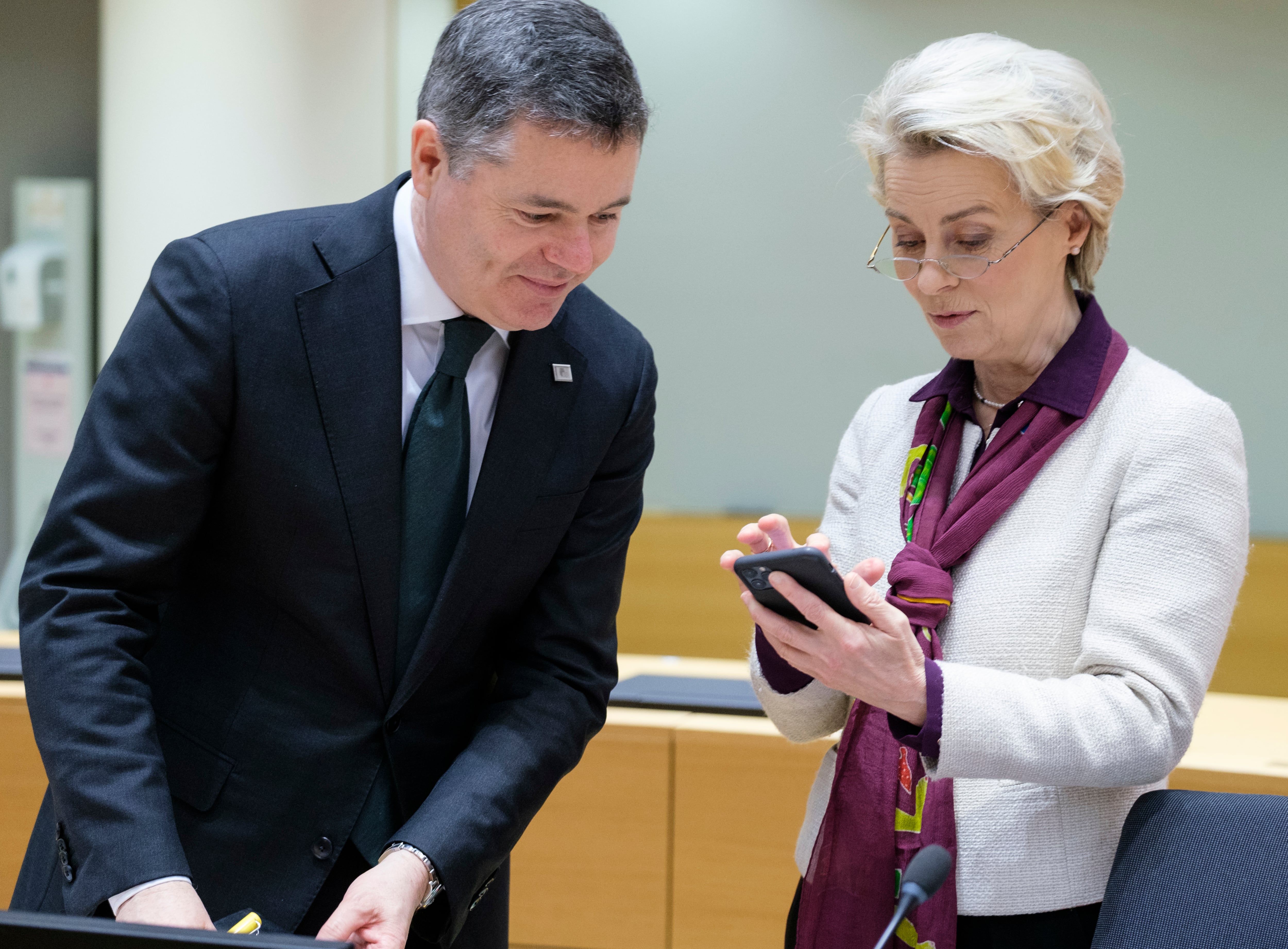 La presidenta de la Comisión Europea, Ursula von der Leyen, consulta su teléfono junto a un ministro irlandés