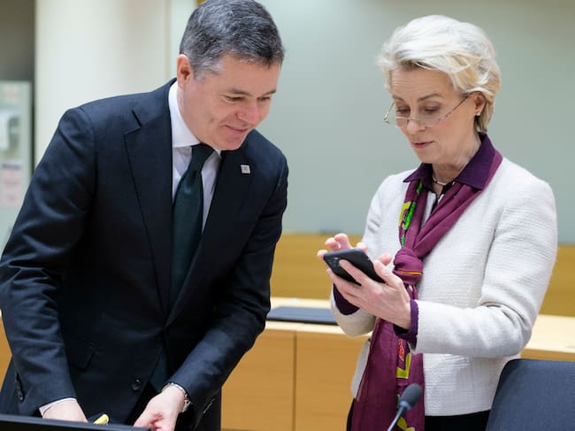 La presidenta de la Comisión Europea, Ursula von der Leyen, consulta su teléfono junto a un ministro irlandés
