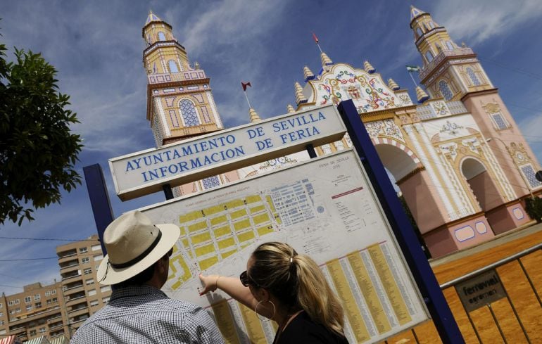 GRA184. SEVILLA, 19/04/2015.- Dos personas miran las indicaciones de las calles del Real de la Feria de abril de Sevilla, que comenzará el próximo lunes con el tradicional &quot;alumbrao&quot;, y que ya tienen hoy gran afluencia de público. EFE/Raúl Caro