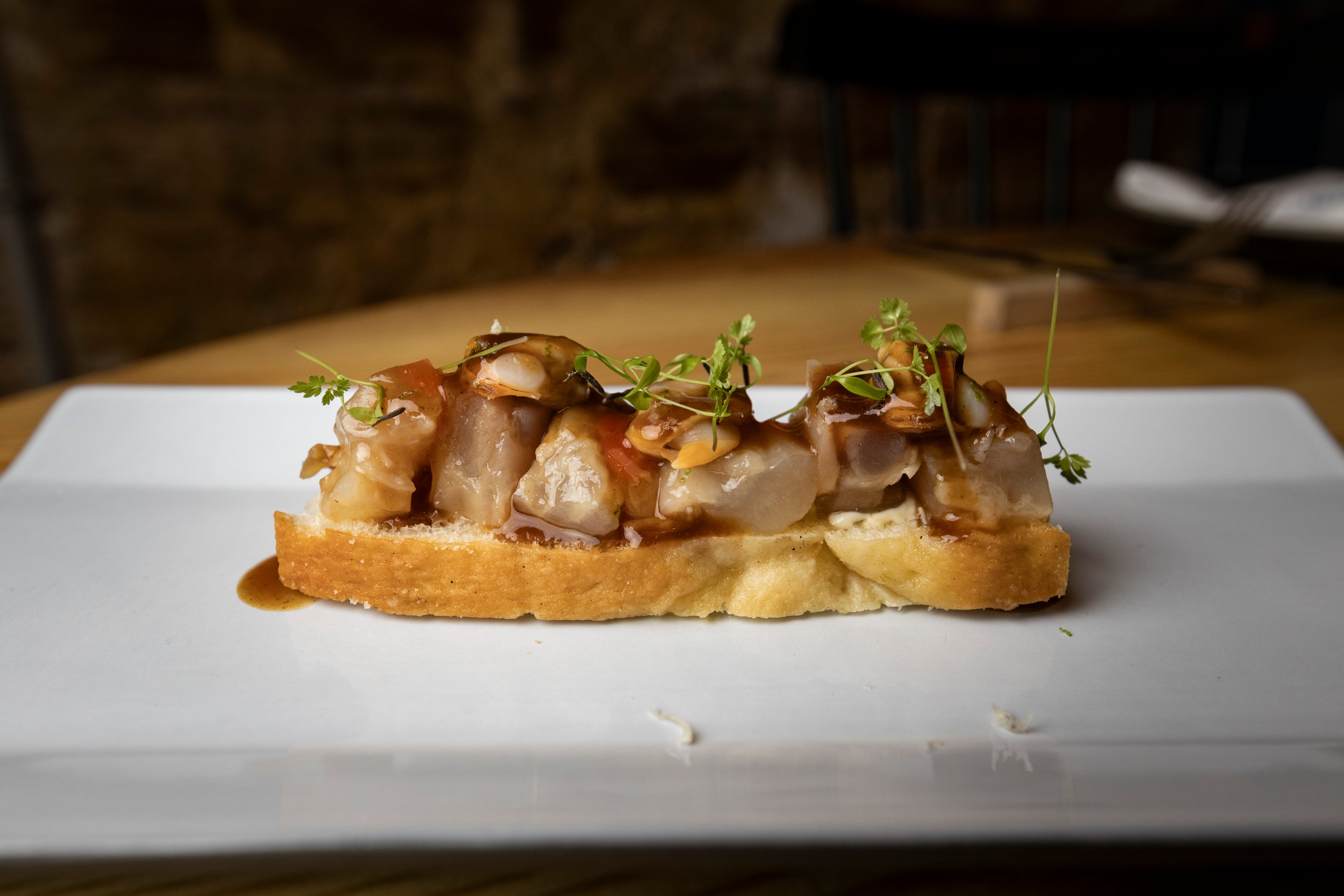 &#039;Focaccia&#039; de tendones de ternera, berberechos, mahonesa de lima y brotes (La Tasquería).