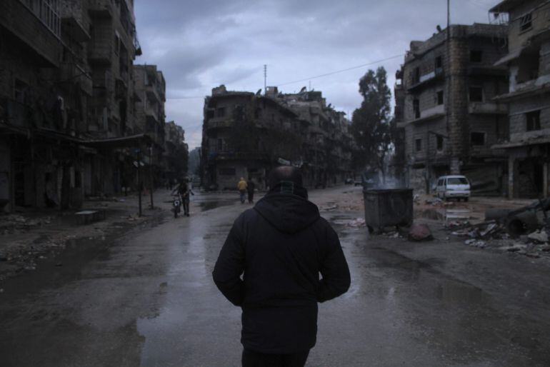 Varias personas caminan por las calles del barrio de al-Mashad en la zona controlada por los rebeldes en Alepo (Siria)