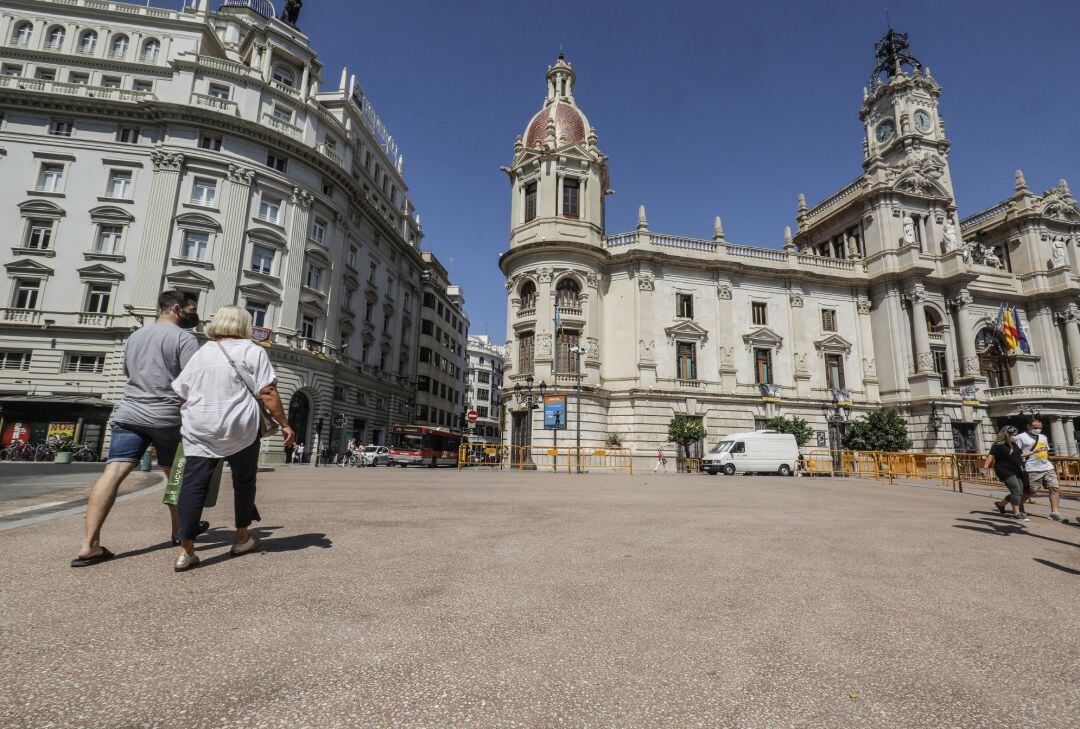 Varias personas pasean por las inmediaciones de las obras de la plaza del Ayuntamiento de Valencia