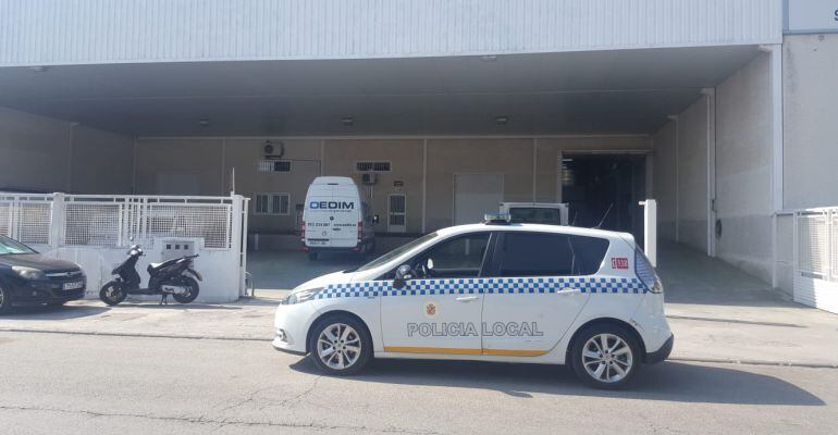 Vehículo de la Policía Local de Jaén en la puerta de la nave donde se ha producido el accidente.