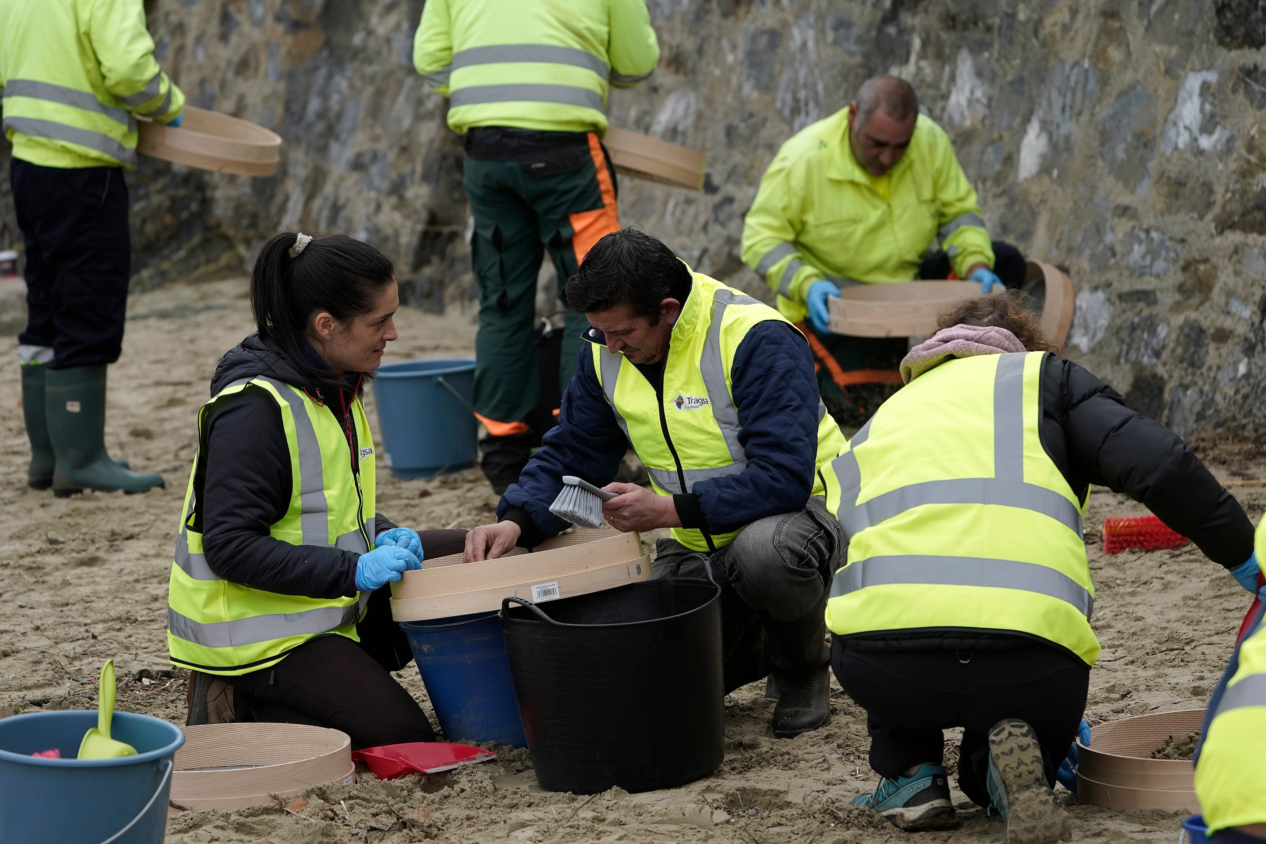 PLAYA DEL AGUILAR (ASTURIAS), 09/01/2024.- Operarios retiran los pellets o bolitas para fabricar plástico que aparecen en las playas de Asturias, tras la caída de un contenedor de un barco el pasado diciembre, esta mañana enla playa asturiana del Aguilar. EFE/Paco Paredes
