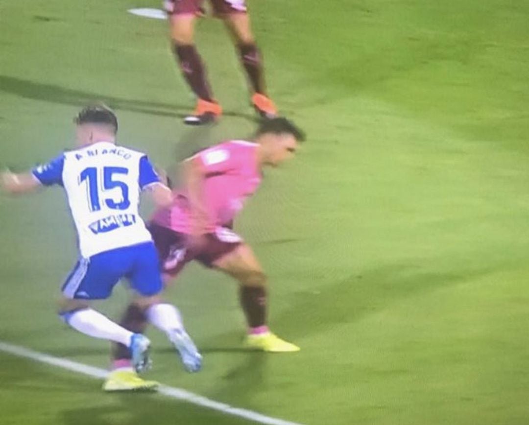 Momento en que Álex Blanco es objeto de falta por parte de un futbolista blanquiazul en el transcurso del Real Zaragoza-Tenerife.