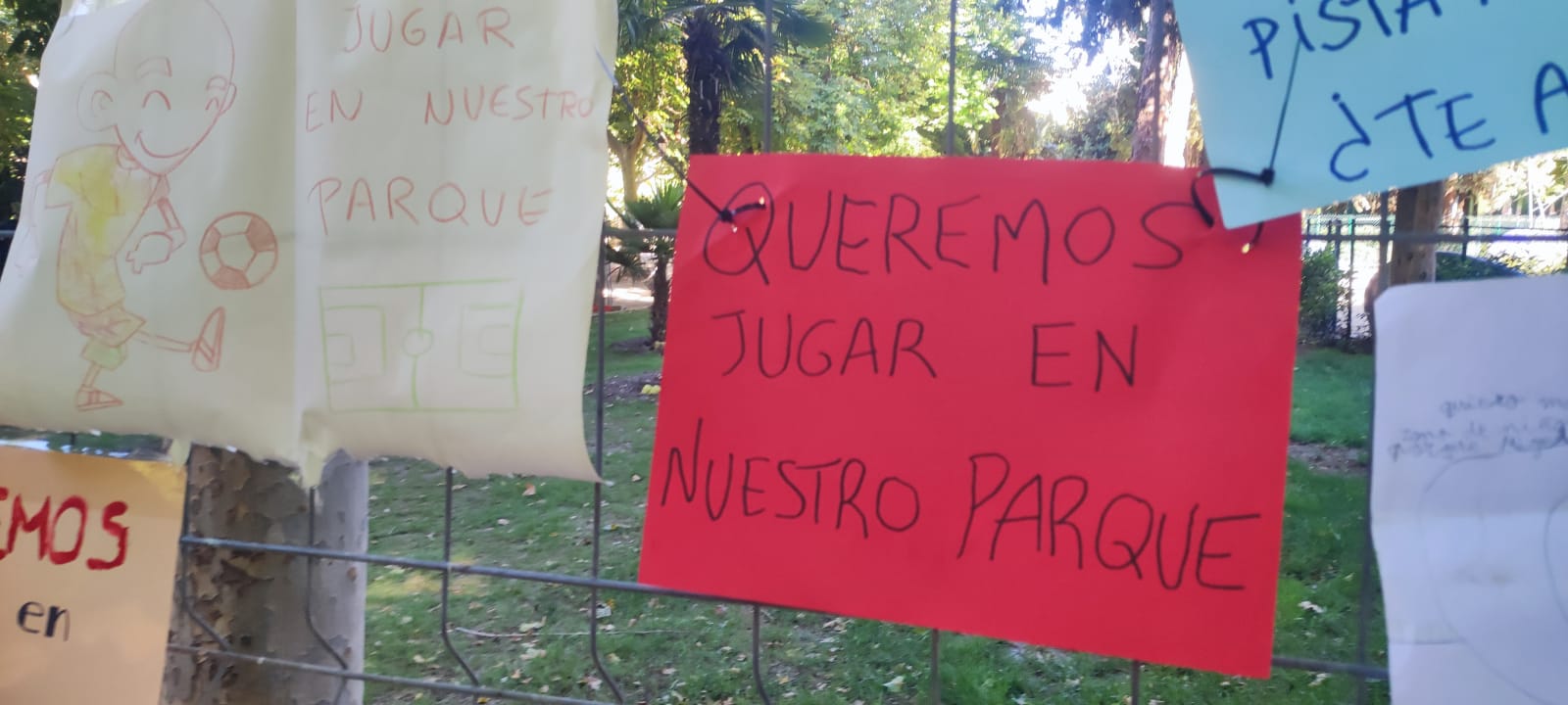 Carteles reivindicativos en la valla de la zona en la que se impide jugar a los niños