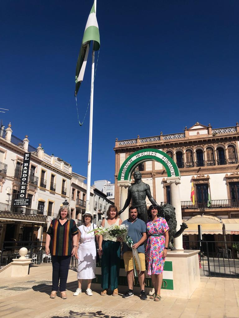 Componentes de la coalición junto a Isabel Barriga debajo de la bandera de Andalucía ubicada en la plaza del Socorro