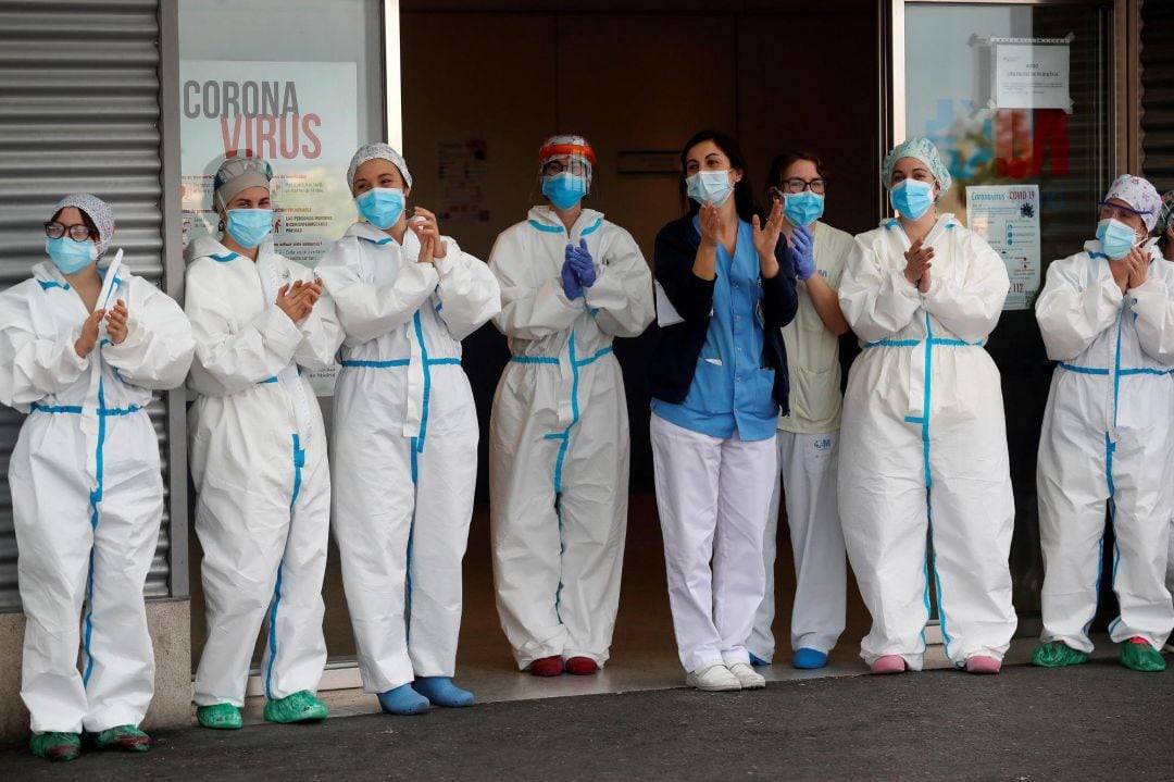 Personal sanitario aplaude a la entrada de un hospital. 