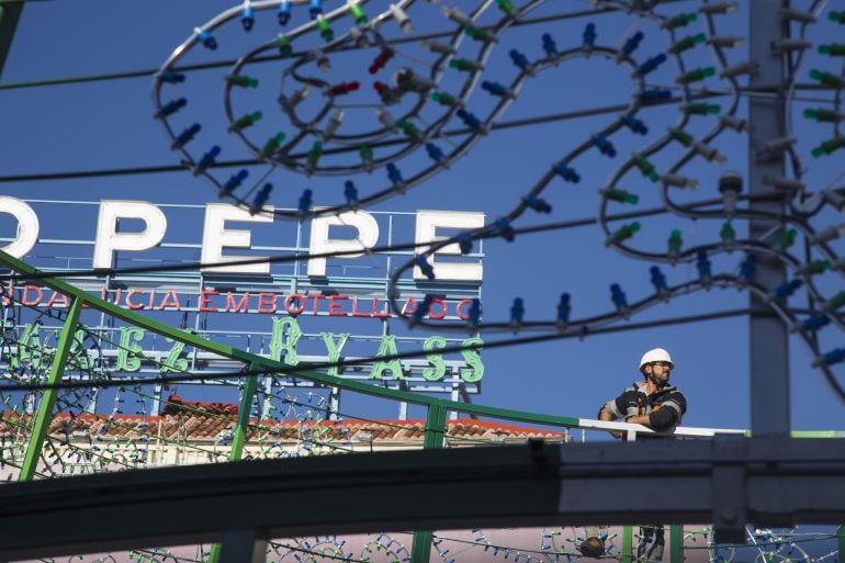 Un obrero, en la Puerta del Sol, monta el árbol de Navidad