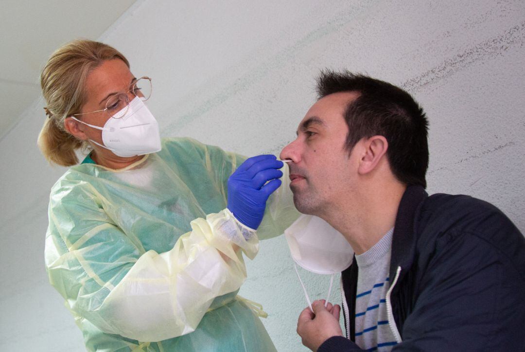 Una sanitaria realiza un test de antígenos o una PCR a un hombre