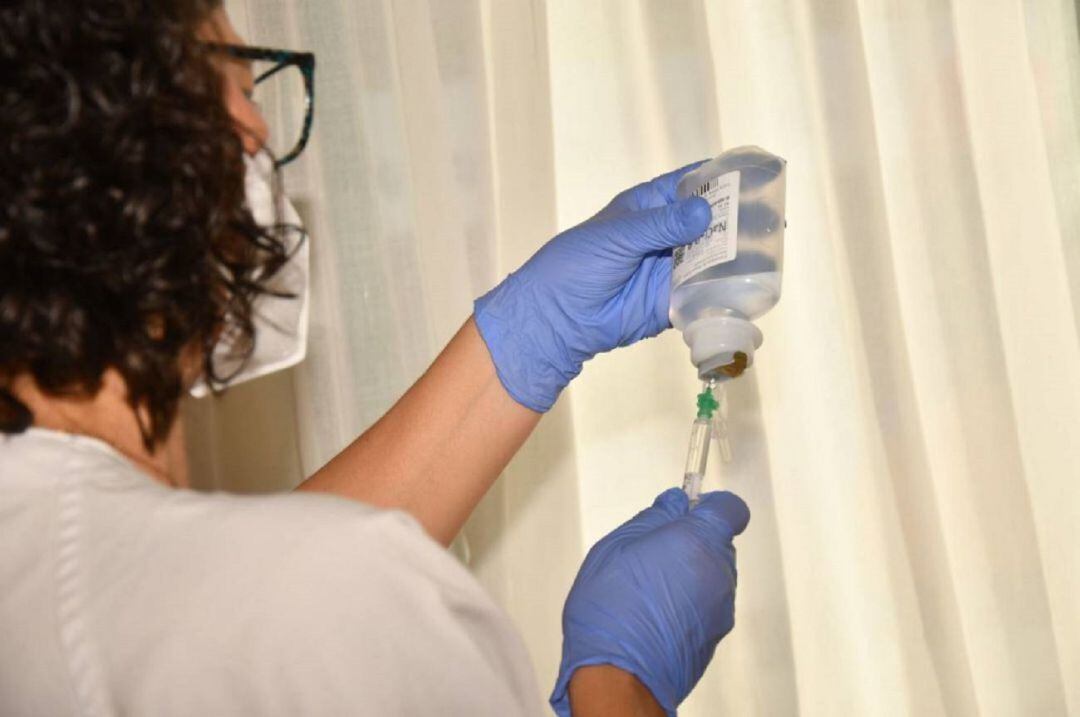 Una sanitaria administra una vacuna.