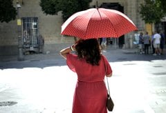 Una mujer se resguarda del calor con un paraguas en el centro de Jerez