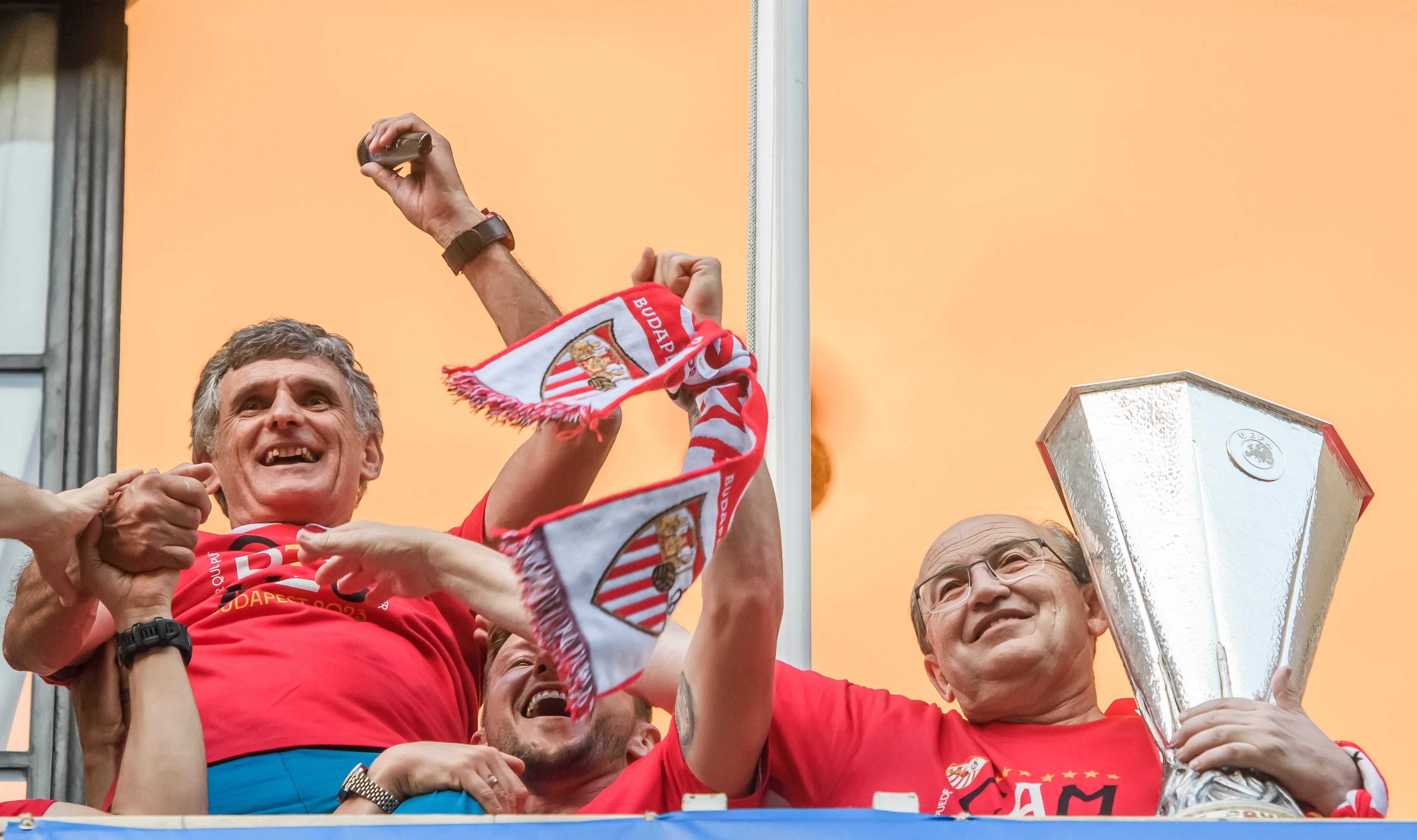 El presidente del Sevilla FC José Castro (d), con la Copa, sujeta al entrenador del equipo, José Luis Mendilivar (i), este jueves en un balcón del Ayuntamiento de Sevilla, donde los jugadores del Sevilla FC, junto al los directivos y cuerpo técnico, celebran la copa de la Liga Europa, séptima del equipo hispalense, cosechada anoche en la final ante la Roma