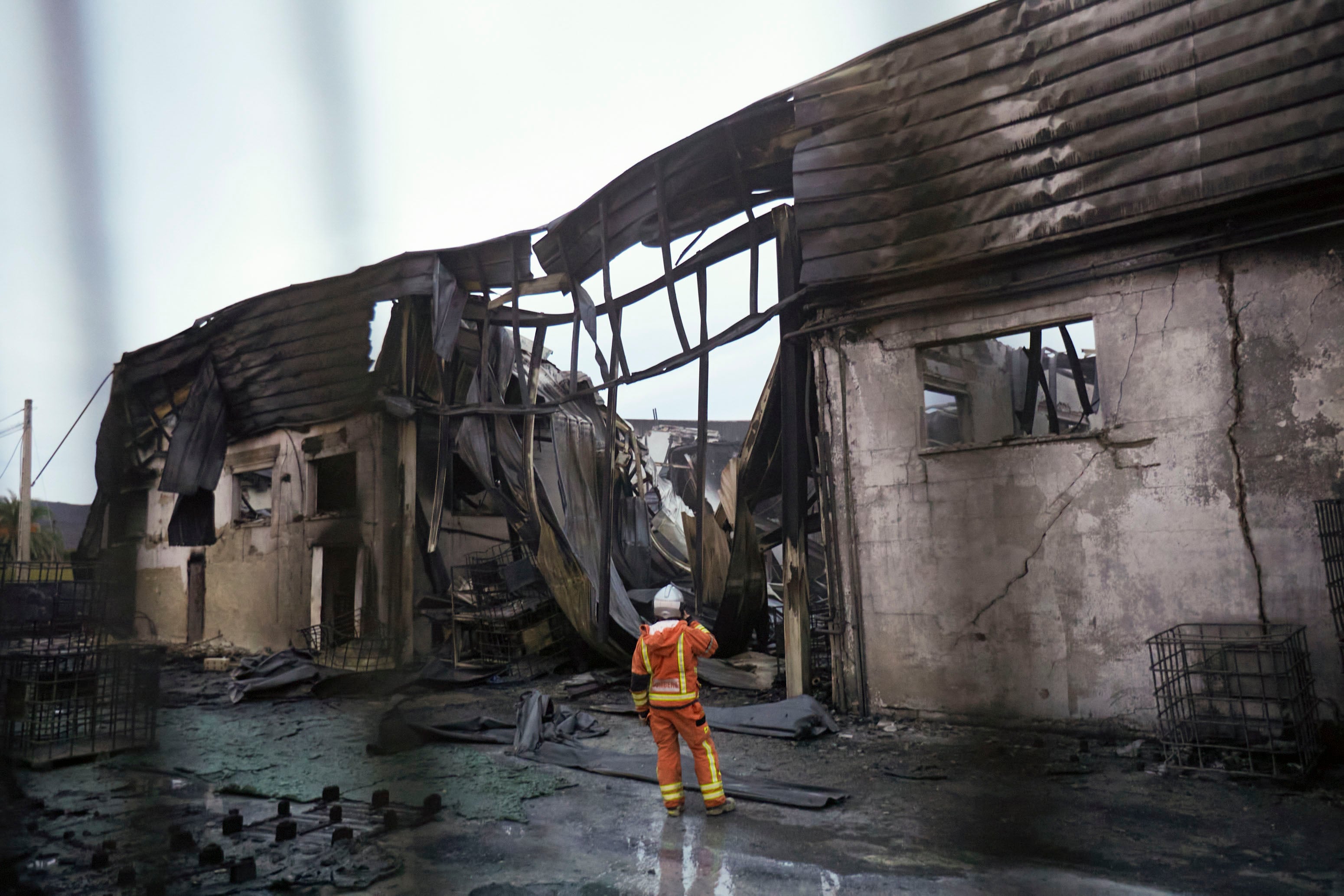 Un bombero revisa las instalaciones de Citrosol en Potries, totalmente calcinadas.