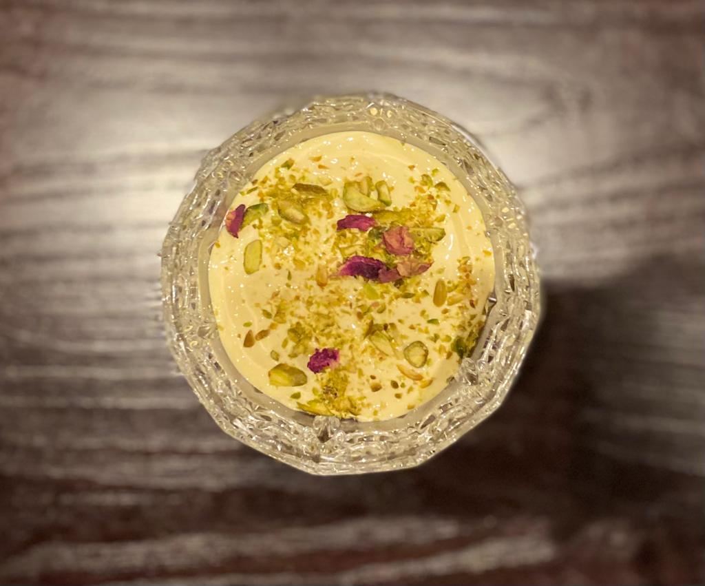 Espuma de leche de azafrán, pistachos y pétalos de rosa