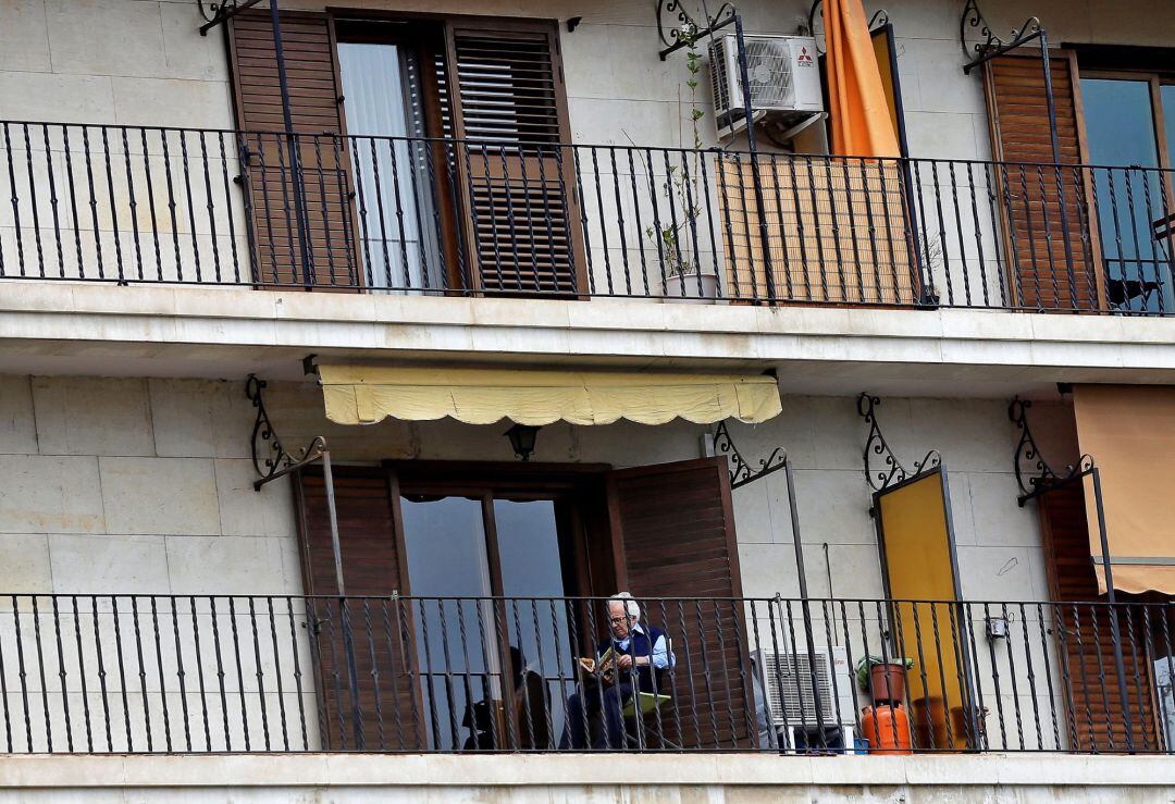 Un hombre lee en el balcón de su vivienda este jueves que se celebra el Día del Libro y se cumplen cuarenta de confinamiento