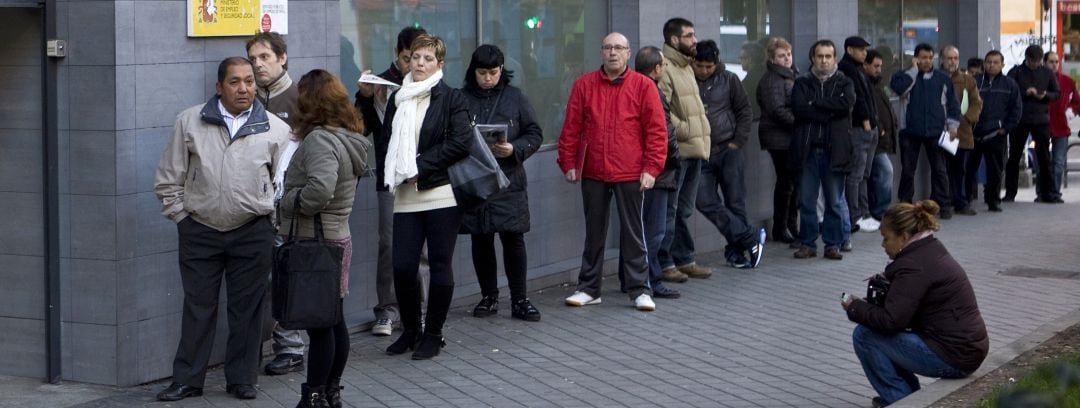 Personas a la cola del paro en una oficina de empleo