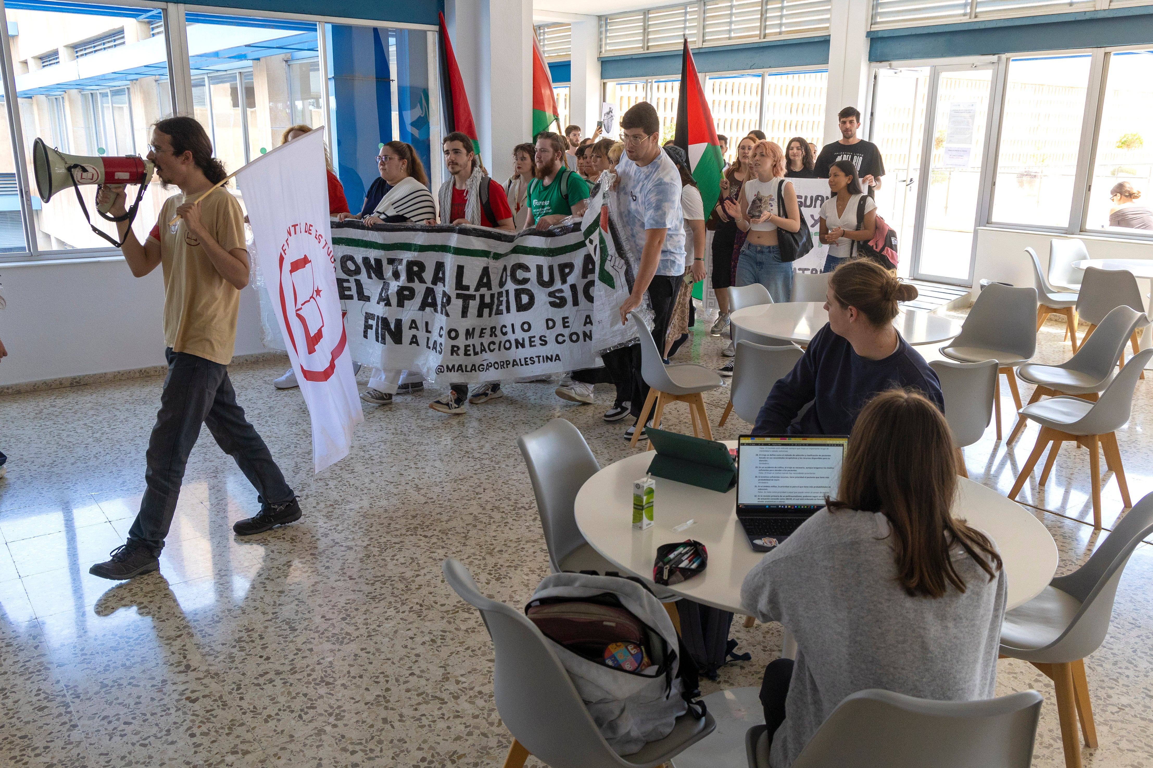 GRAFAND1141. MÁLAGA, 13/05/2024.- Los estudiantes que mantienen un encierro indefinido desde el pasado jueves en la Biblioteca General de la Universidad de Málaga (UMA) han accedido este lunes a la Facultad de Medicina durante la manifestación convocada tras leer un manifiesto ante los medios en el que exigen que esta institución rompa los convenios que mantiene vigentes con universidades y entidades que &quot;apoyan el genocidio israelí contra el pueblo palestino&quot;. EFE/Álvaro Cabrera
