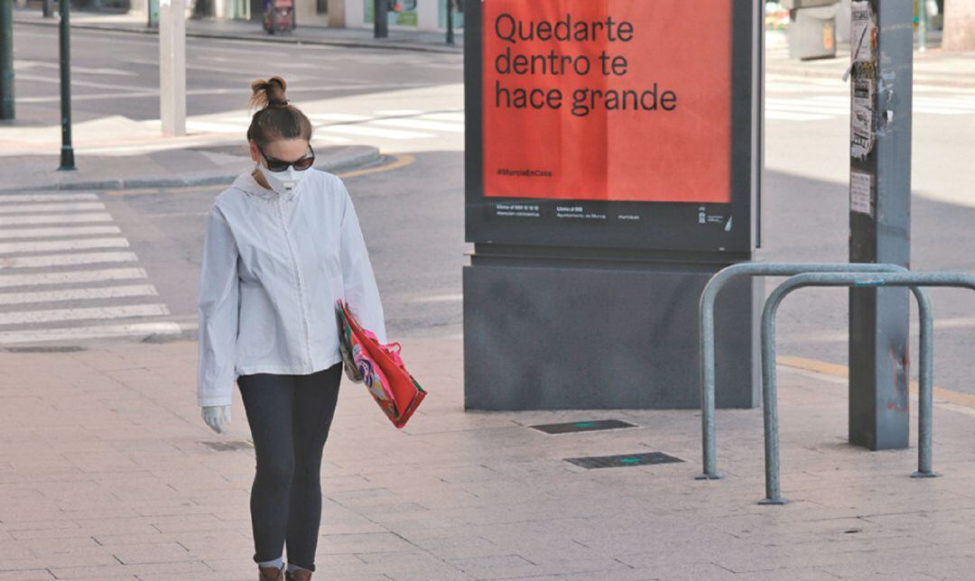 Una mujer camina con mascarilla por las calles desiertas de Jaén