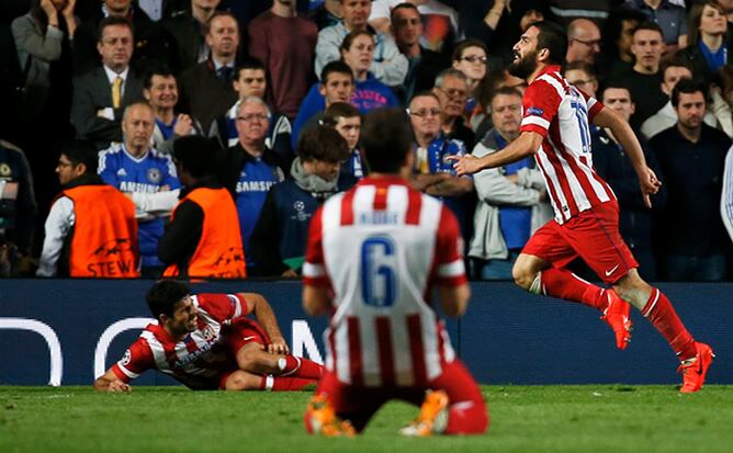 El jugador turco celebra su gol ante el Chelsea con Diego Costa en el suelo y Koke presenciando la escena de rodillas.
