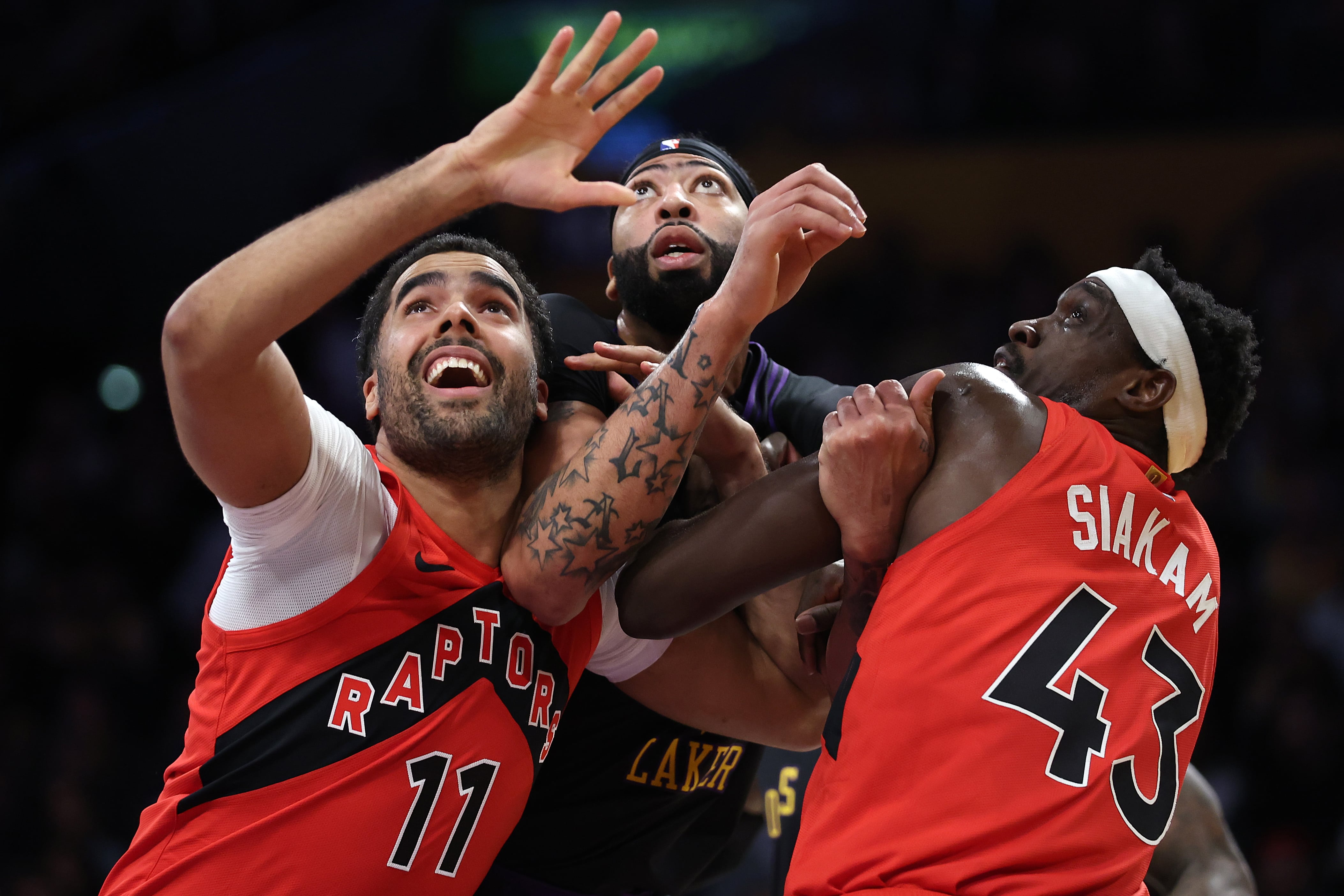 Jontay Porter y Pascal Siakam presionan a Anthony Davis en el rebote