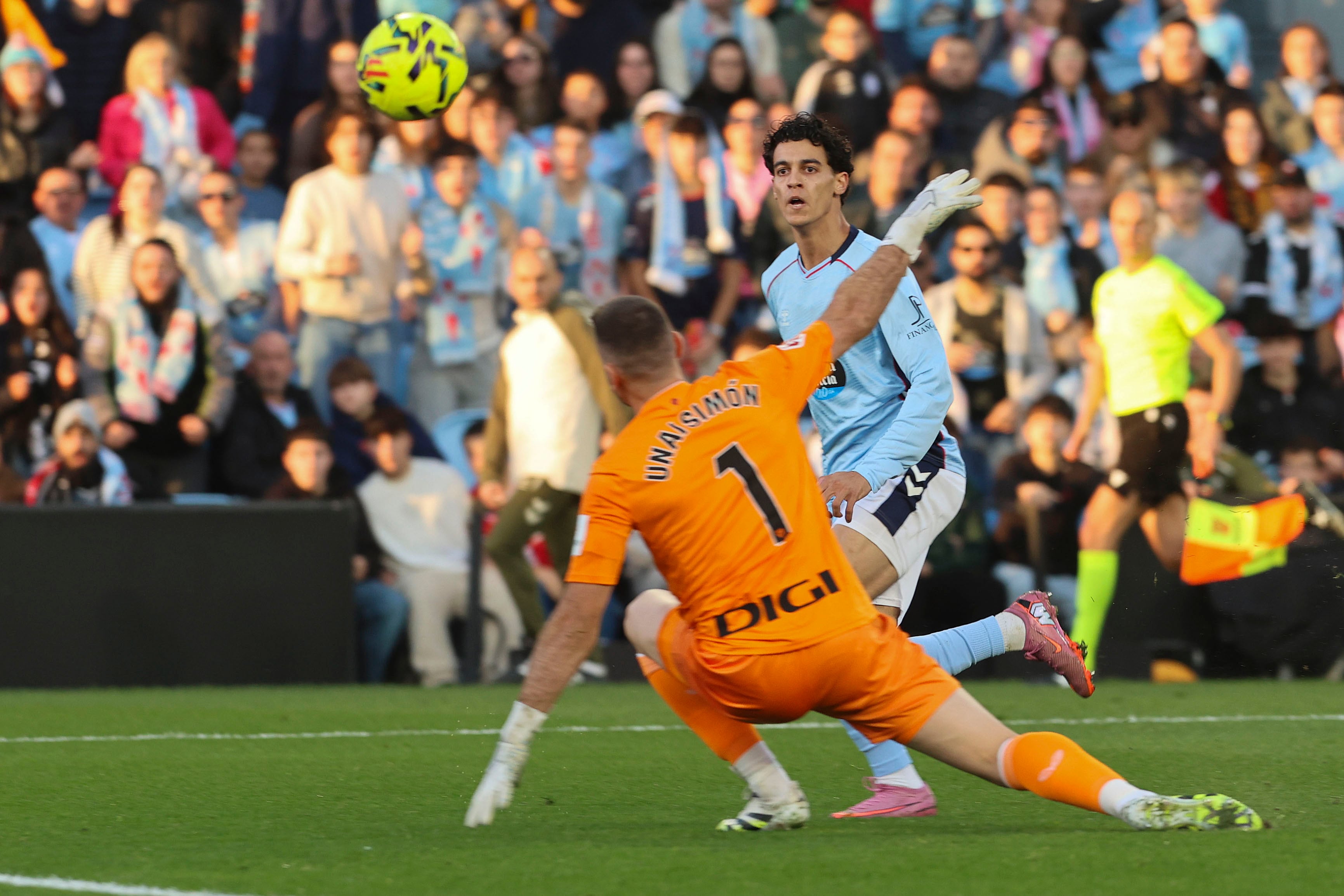 VIGO (PONTEVEDRA), 14/12/2025.- Jones El Abdellaoui, del Celta, eleva el balón ante el portero del Athletic Unai Simón para marcar el segundo gol del conjunto vigués, durante el partido de LaLiga disputado este domingo en el estadio de Balaídos. EFE/Salvador Sas