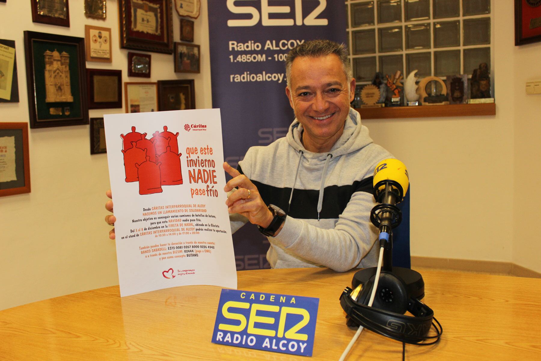José Domingo Sempere en el estudio central de Radio Alcoy, muestra el cartel de la campaña