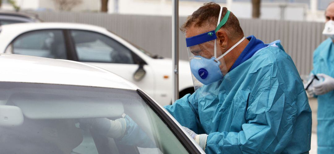 Dispositivo sanitario de la prueba test del PCR para detectar la infección por coronavirus a las personas desde su coche, instalado en el recinto de aparcamiento del centro de salud de la barriada La Roca, en Málaga.