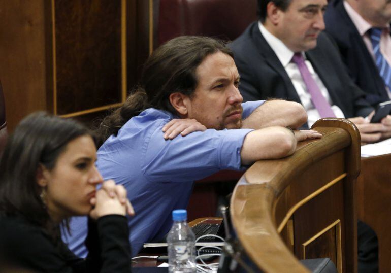 El líder de Podemos, Pablo Iglesias, atento a las intervenciones en el pleno del Congreso, sesión que será la última, ya que el próximo martes las Cortes se disolverán ante la convocatoria de nuevas elecciones