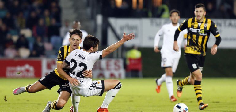 El defensa del Barakaldo CF Unai Elgezabal (i) disputa un balón con el delantero del Valencia Santi Mina (2i), durante el partido de ida de dieciseisavos de final de la Copa del Rey