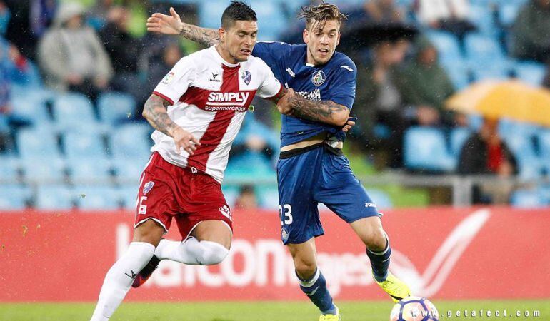 El jugador del Getafe C.F. Álvaro Jiménez (d) lucha por un balón con Jesús, de la S.D. Huesca