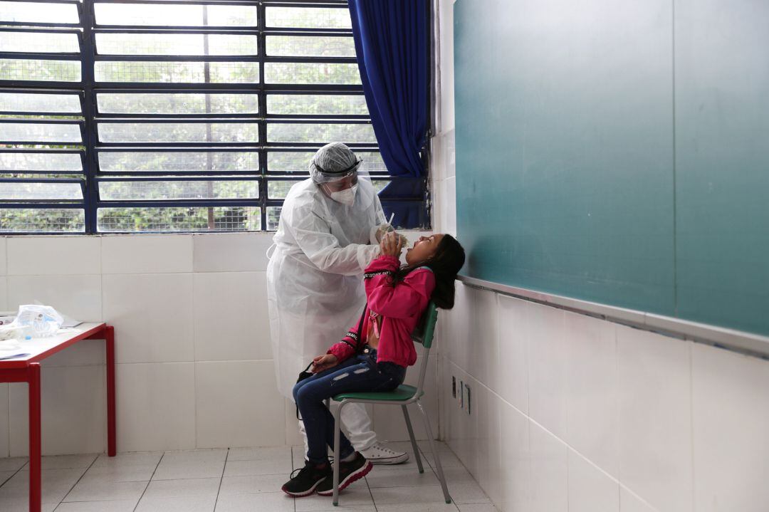 A healthcare worker performs a PCR test on student