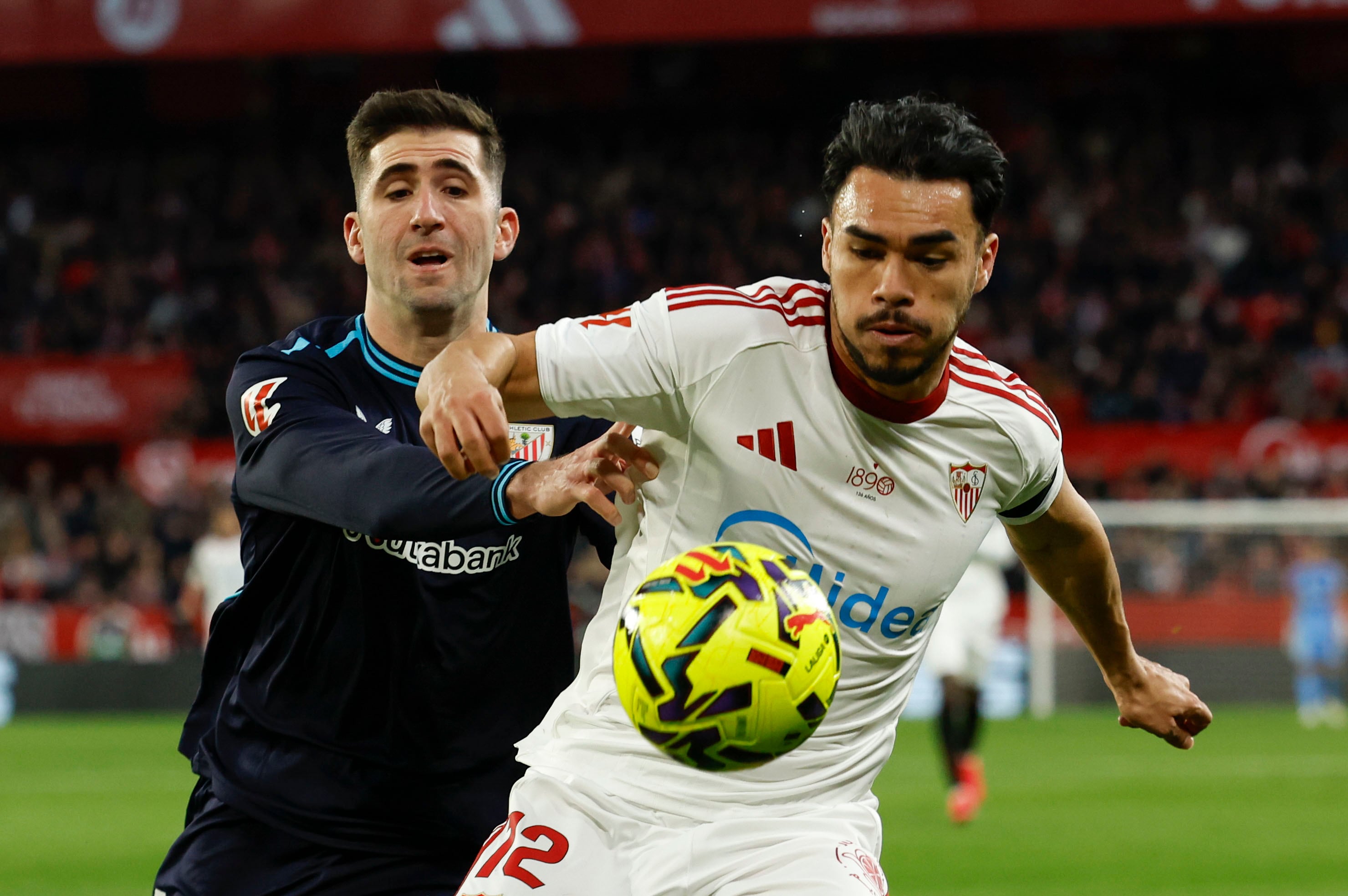 SEVILLA, 24/01/2026.- El defensa chileno del Sevilla, Gabriel Suazo (d), disputa el balón ante el defensa del Athletic Club, Jesús Areso, durante el encuentro correspondiente a la jornada 21 de Laliga EA Sports que disputan hoy sábado en el estadio Sánchez Pizjuán de Sevilla. EFE / Julio Muñoz.