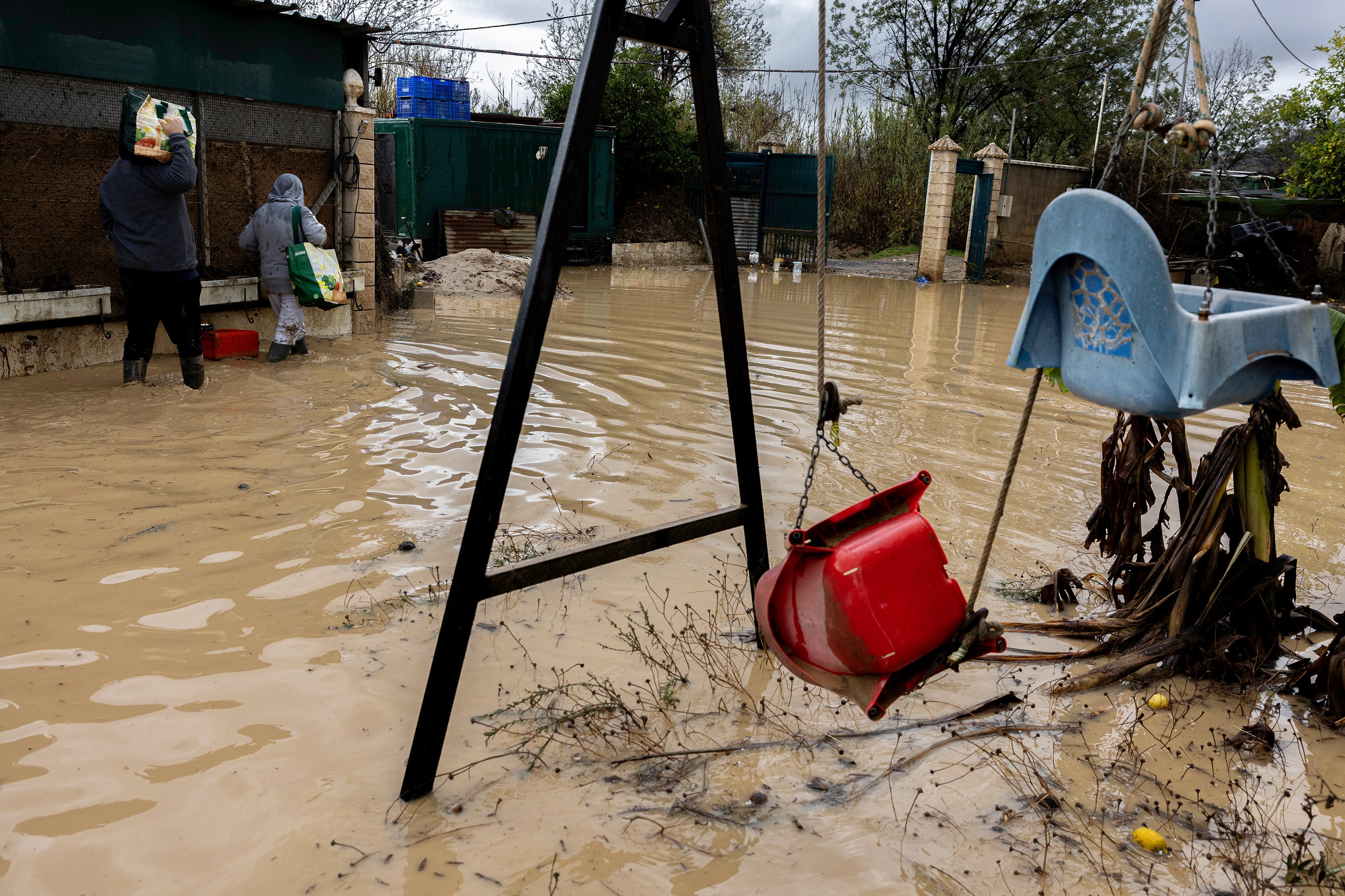 CÁRTAMA (MÁLAGA), 30/10/2024. Unas personas abandonan su casa en la barriada de Doña Ana en la Estación de Cártama en Málaga, afectada por el desborde del río Guadalhorce a consecuencia de las precipitaciones en la comunidad autónoma andaluza provocadas por la DANA que cruza la región. EFE/Jorge Zapata.
