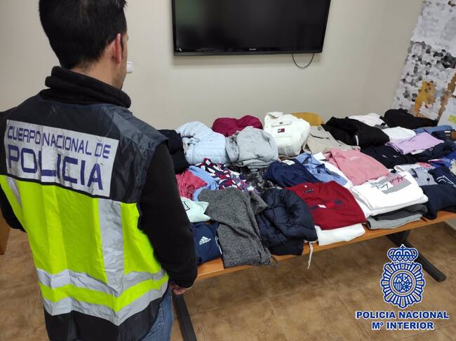 Un agente junto a las prendas aprehendidas