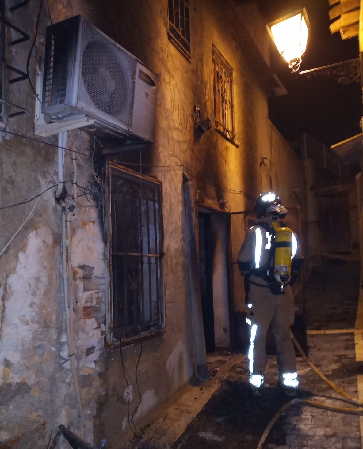 Un bombero permanece a las puertas de la vivienda incendiada en Ricote donde han fallecido tres personas