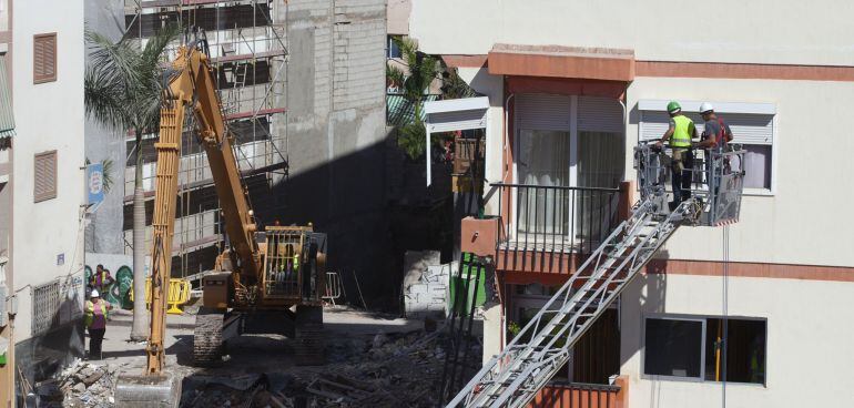 Unos obreros trabajan en uno de los pisos del edificio que ayer se derrumbó en el centro de Los Cristianos, del que se han rescatado dos cadáveres y nueve personas continúan desaparecidas, mientras sigue la investigación sobre las causas del desplome