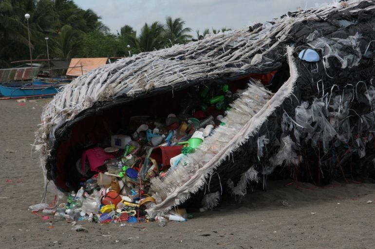 Greenpeace Filipinas muestra una instalación de arte que representa a una ballena muerta por el plástico y la basura situada a lo largo de la costa del municipio de Naic, provincia de Cavite, Filipinas.