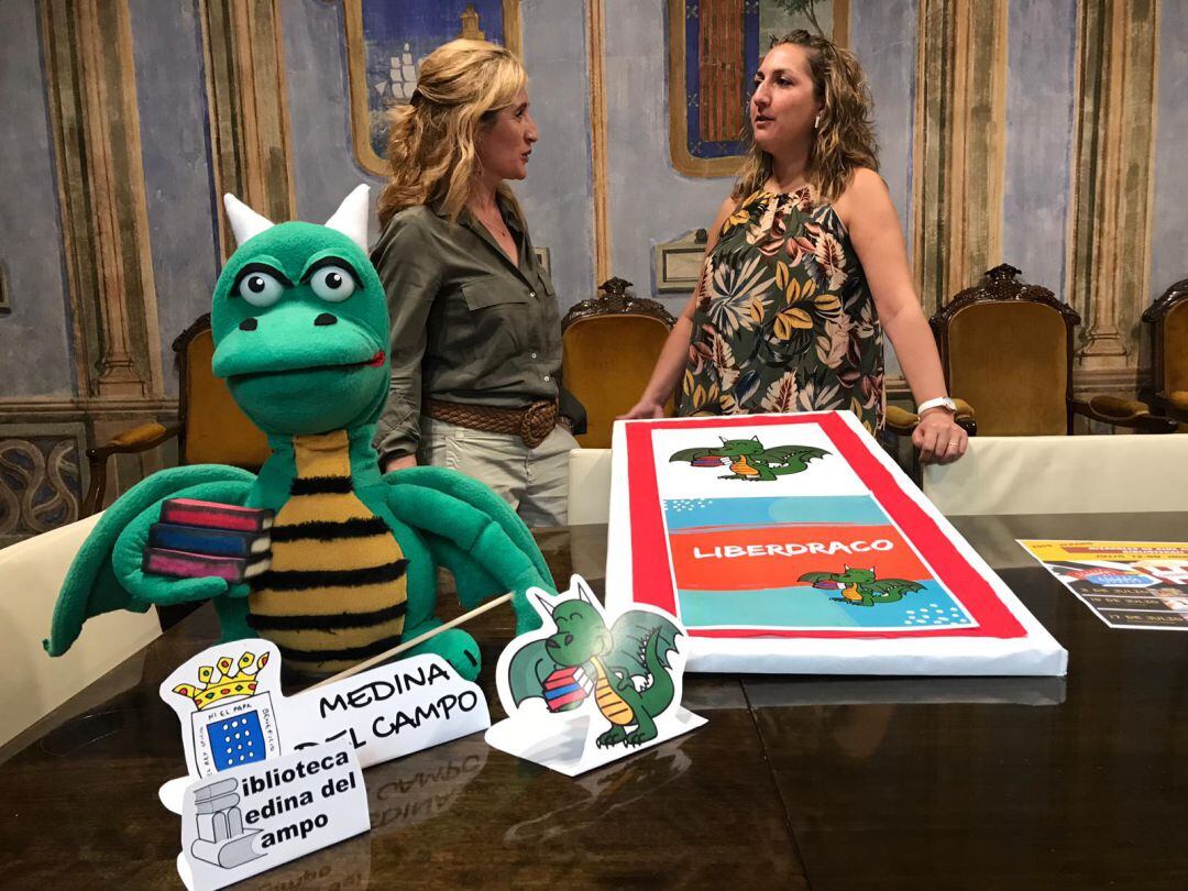 Beatriz Guerra, directora de la Biblioteca y Cristina Aranda, edil de Cultura, junto a la mascota del centro