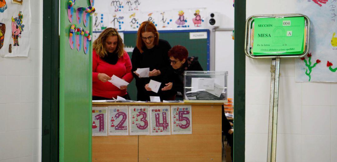 Tres personas recuentan los votos en unas elecciones.