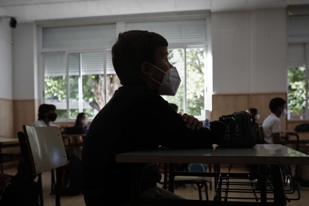 Un niño con mascarilla en un aula de un colegio