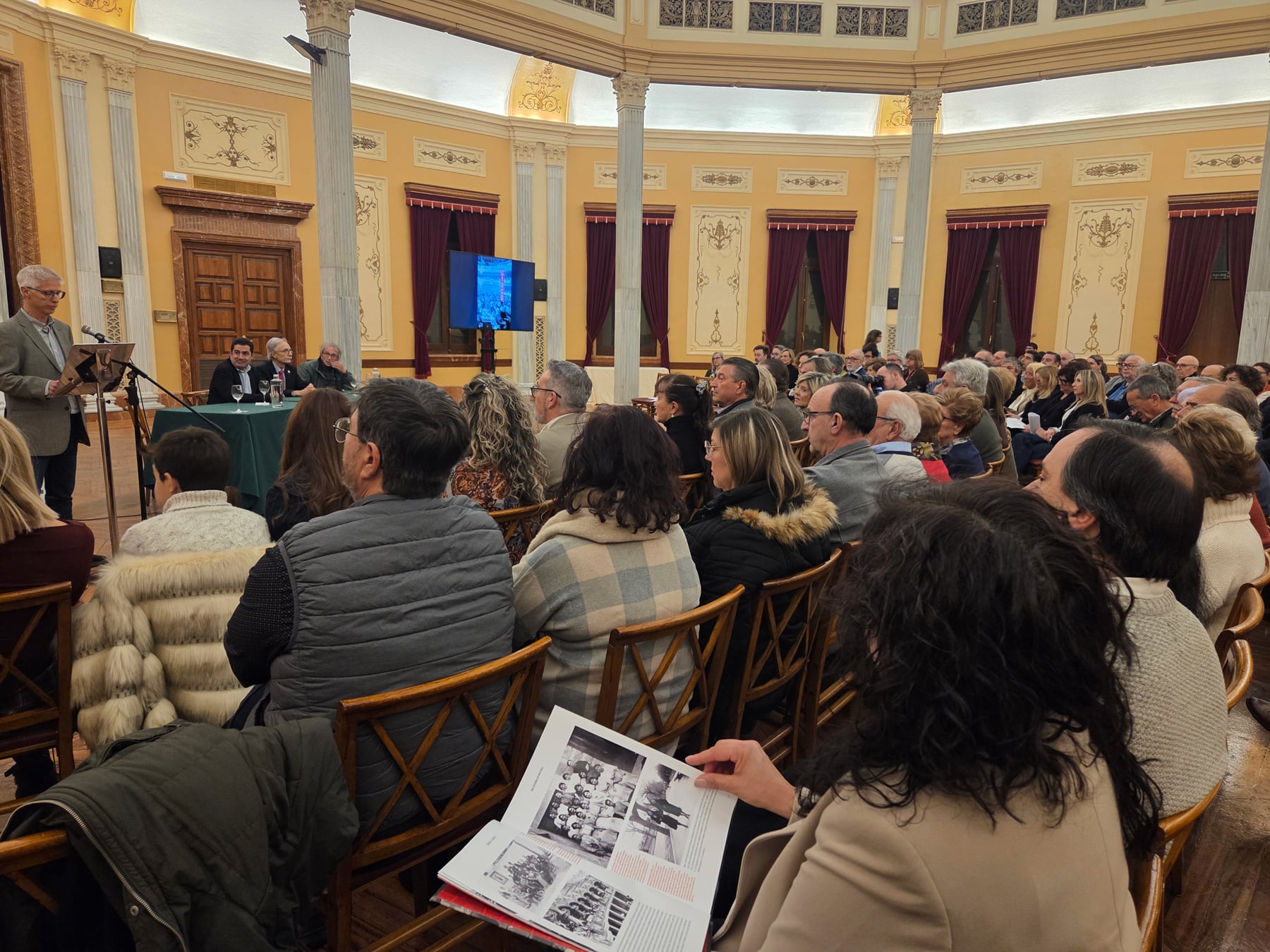 Una de las asistentes al acto de presentación ojea uno de los ejemplares de 'Teatro Circo. Una historia de película'