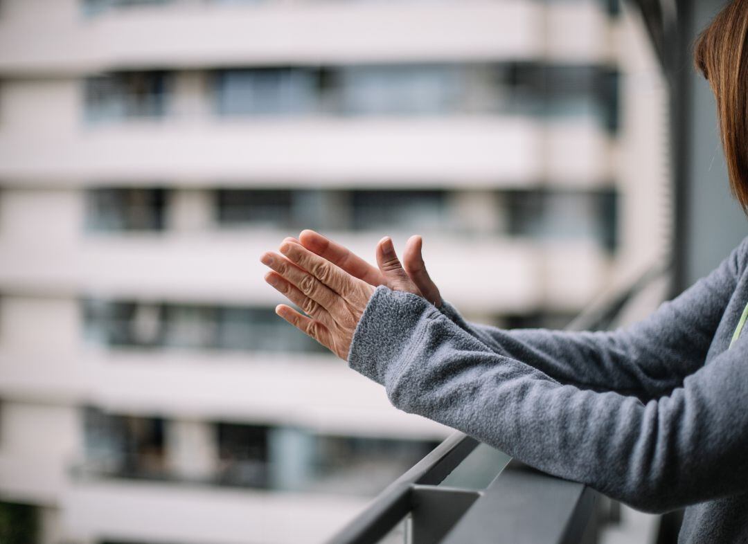 Una mujer aplaude a los servicios de emergencia en la crisis del coronavirus