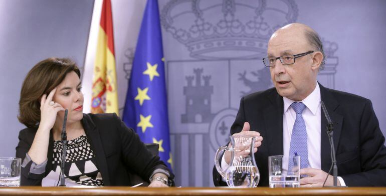La vicepresidenta del Gobierno, Soraya Sáenz de Santamaría, acompañada por el ministro de Hacienda, Cristóbal Montoro