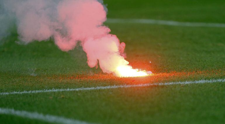 Una bengala en el estadio Vicente Calderón tras el gol del Benfica durante el encuentro del Grupo C de la Liga de Campeones que el Atlético de Madrid y el Benfica disputan esta tarde