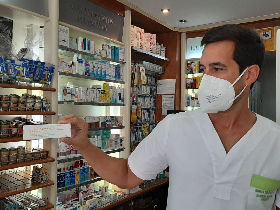 Un farmaceútico muestra una de las pocas vacunas de la gripe que están llegando a las farmacias de Málaga