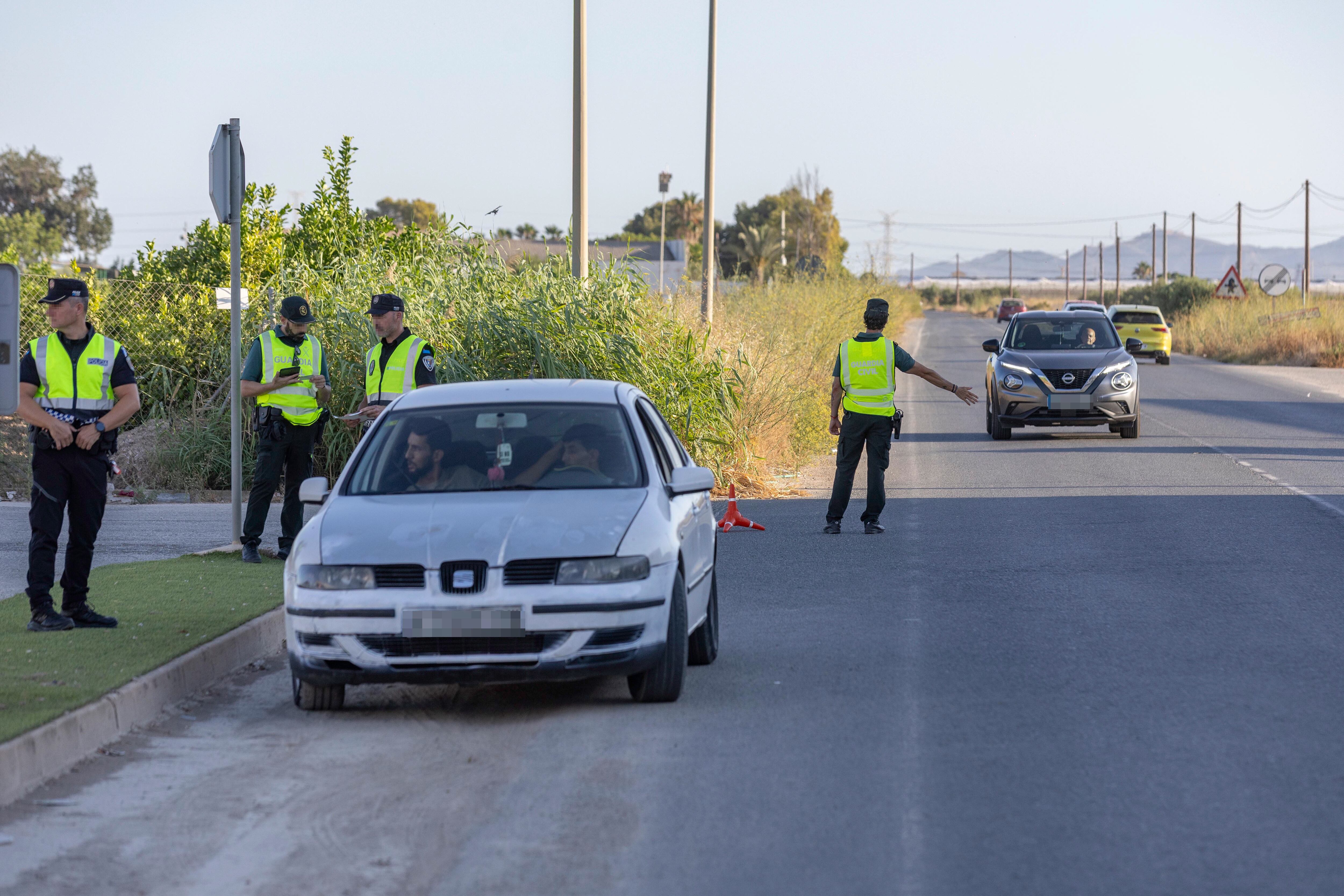 TORRE PACHECO (MURCIA), 19/07/2025.- Agentes de la Guardia Civil y la Policía Local de Torre Pacheco controlan el acceso al municipio. Este sábado se cumplen 10 días de la violenta agresión al vecino de 68 años que desencadenó los disturbios de corte racista en un municipio de 41.000 habitantes y con un 30 por ciento de población inmigrante. EFE/Marcial Guillén