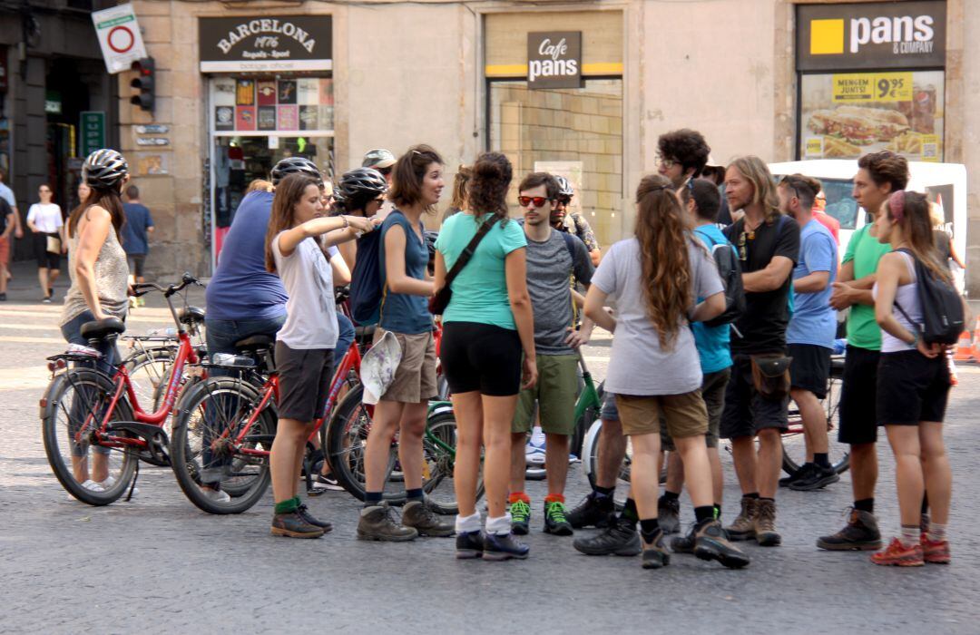 Grup de turistes amb bicicletes a la Plaça Sant Jaume de Barcelona